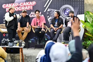 Anggota komunitas fotografi sedang berpartisipasi dalam sesi tanya jawab mengenai teknik fotografi