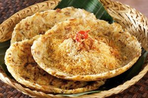 Kerak telor khas Betawi, makanan tradisional yang terbuat dari beras ketan, telur bebek, serundeng kelapa, dan ebi, disajikan di atas daun pisang dalam wadah anyaman bambu