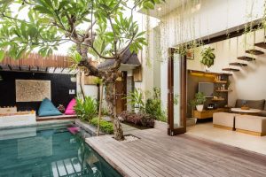 Desain villa tropis di Bali dengan perpaduan arsitektur modern dan unsur tradisional, dilengkapi kolam renang, area santai, serta interior terbuka yang menyatu dengan alam