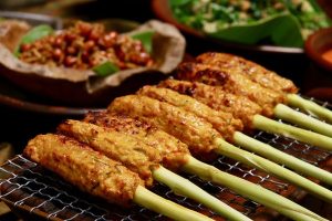 Sate lilit khas Bali dengan daging cincang berbumbu, dililit pada batang serai dan dipanggang hingga matang