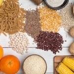 sumber karbohidrat dengan indeks glikemik rendah, termasuk oatmeal, quinoa, kacang-kacangan, dan disajikan di atas meja kayu