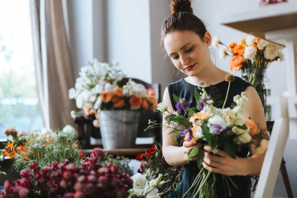 Proses perangkai bunga oleh florist profesional dengan buket bunga segar